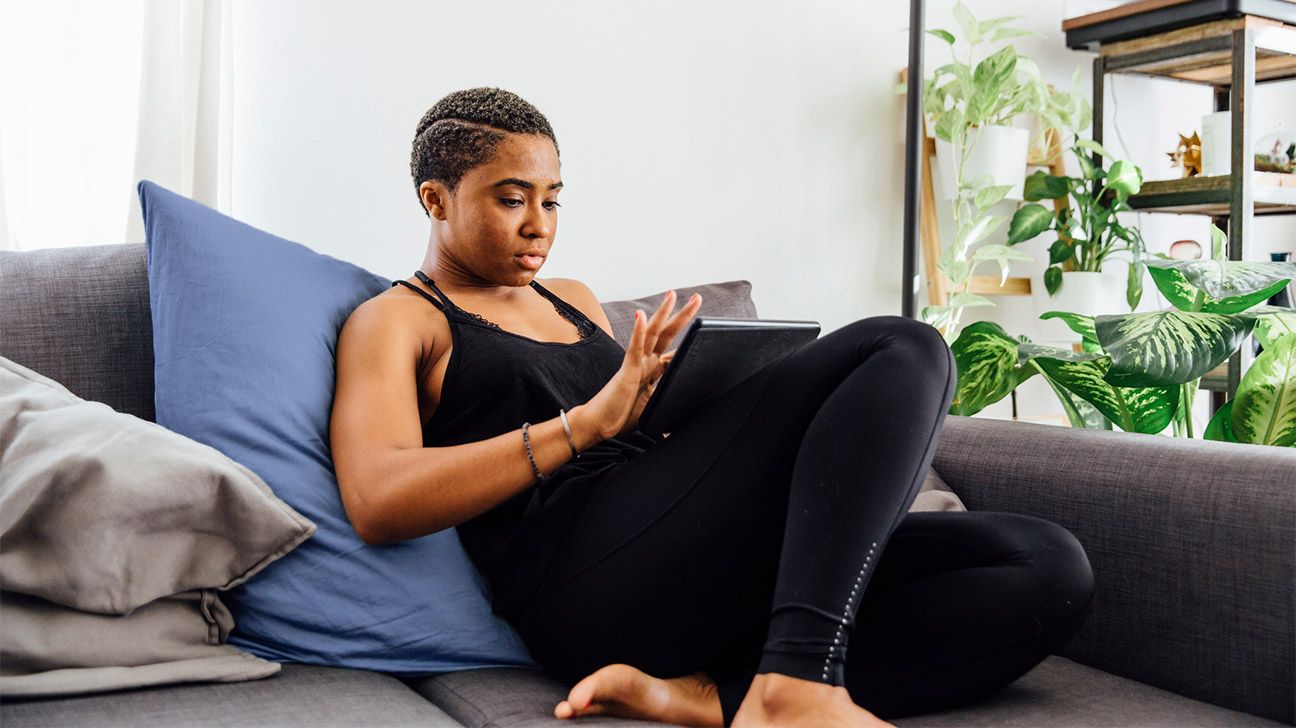 young woman on couch using ipad