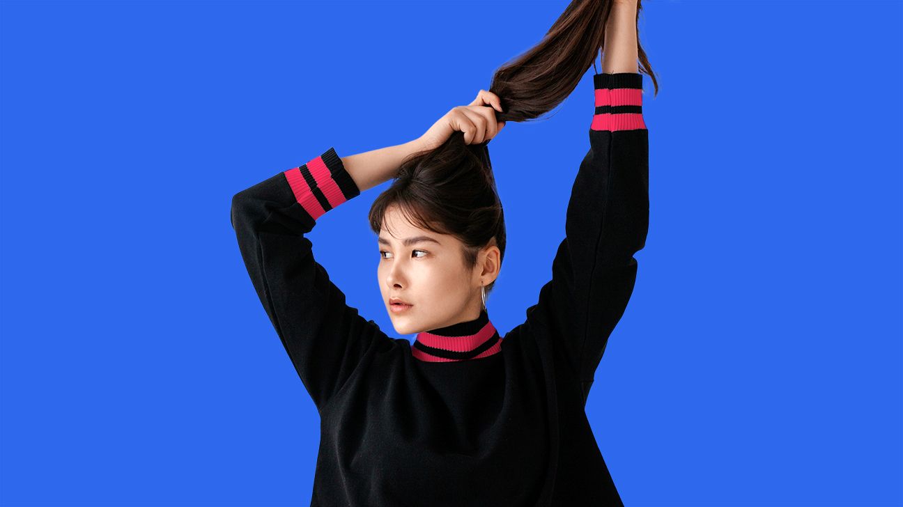 young woman holding hair up in a pony tail