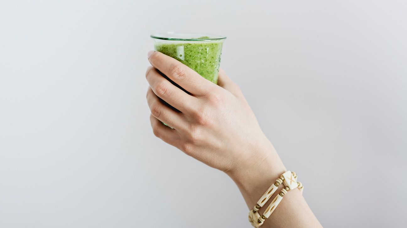 person holding a green smoothie