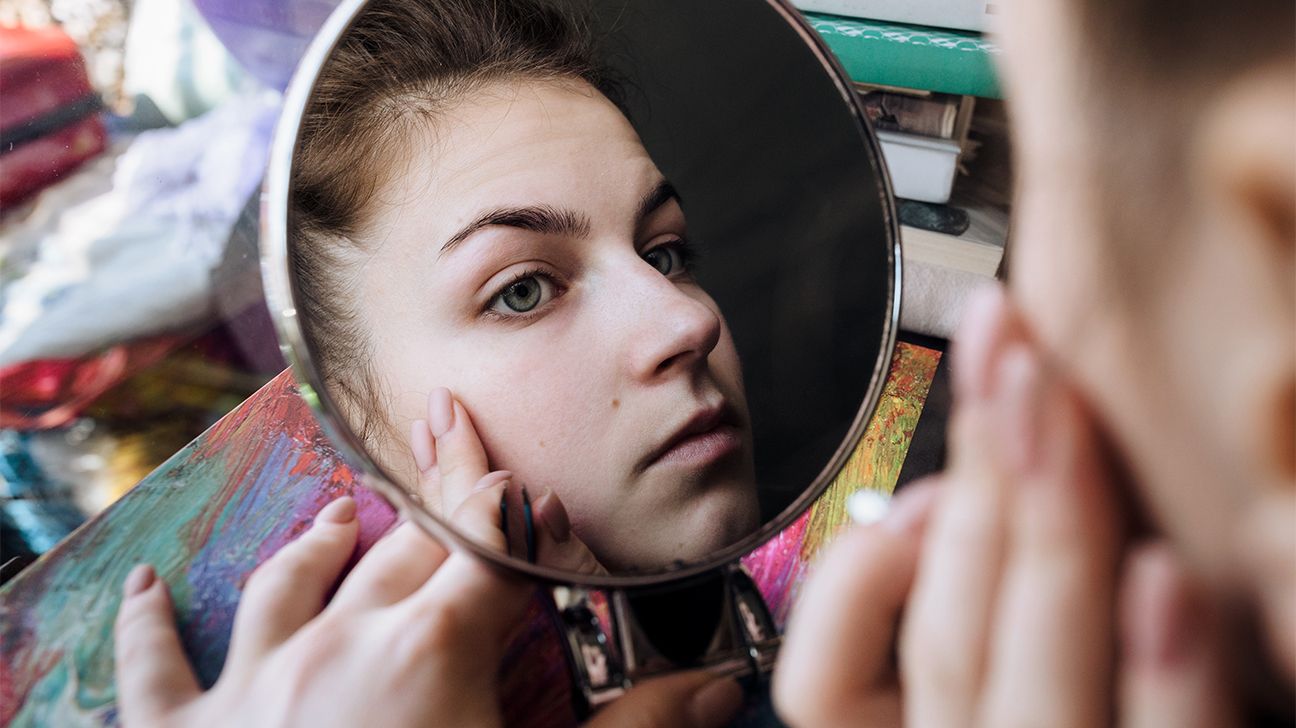woman examines blind pimple in mirror header