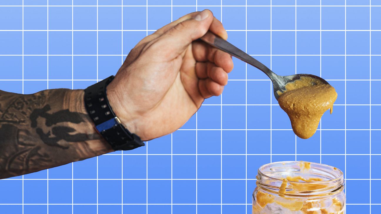 guy's hand with a spoon of peanut butter