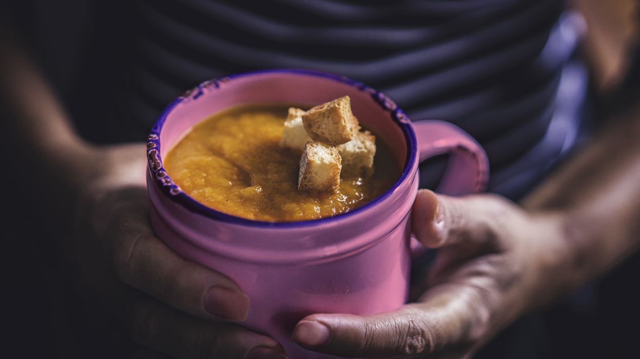 purple cup of slow-cooked soup and croutons fall classic header