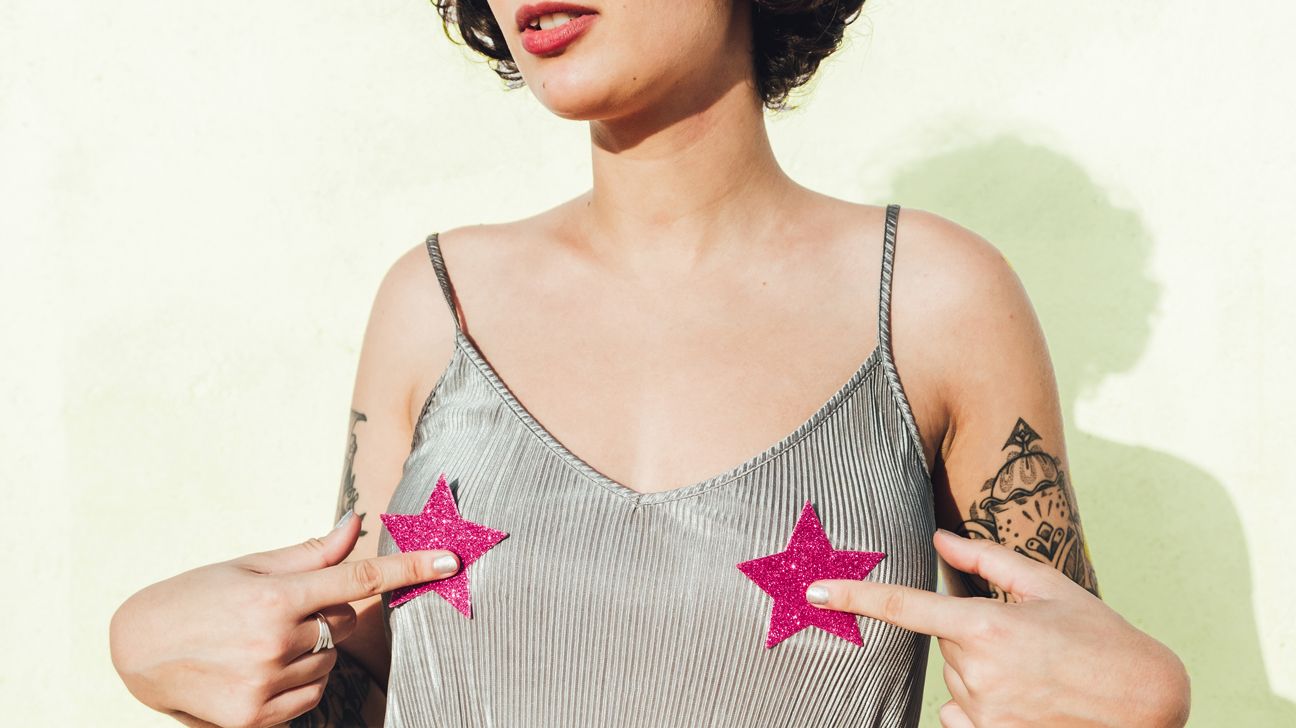 Young woman with star stickers on her breasts over a tank top 