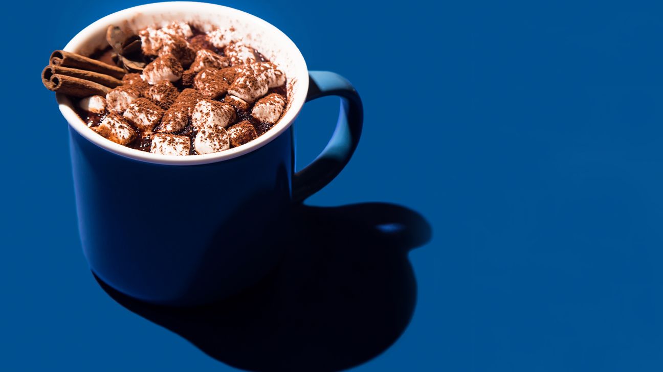 a blue mug of extra fancy hot cocoa on a blue background