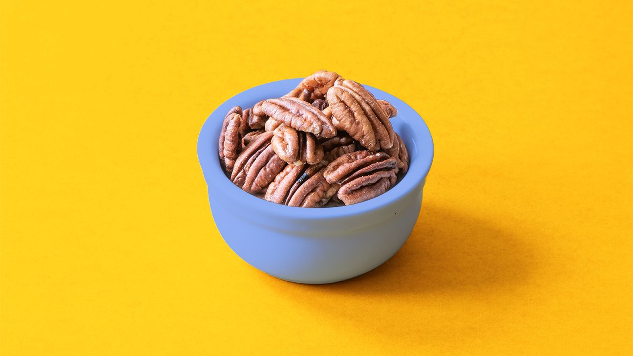 pecan nuts in a bowl on yellow background header