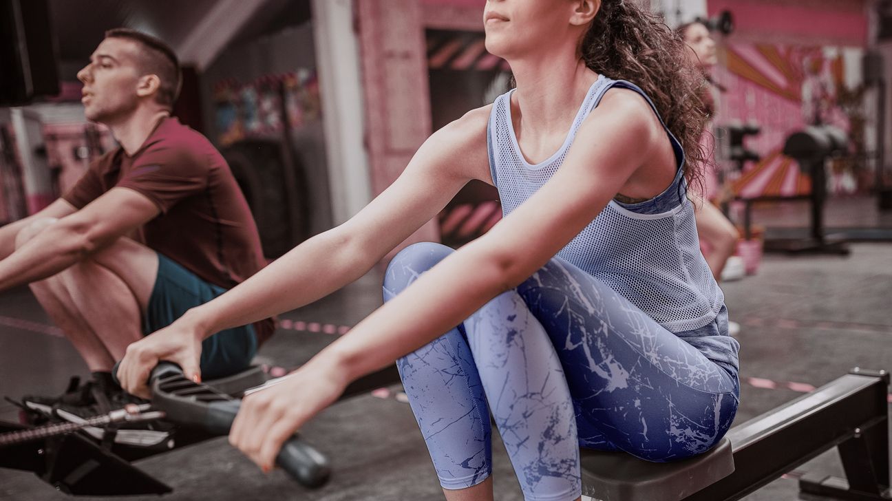 Young woman exercisinig on a rowing machine 