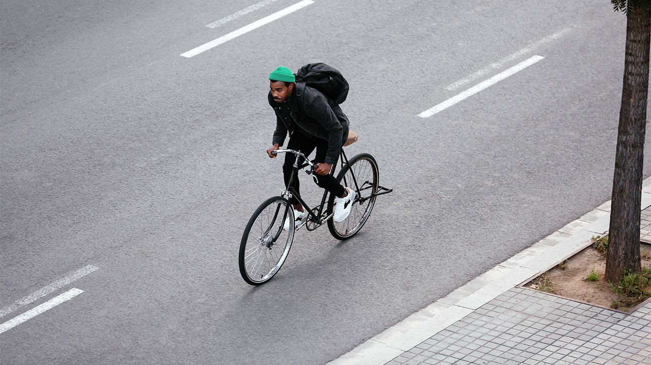 man rides bike in city header