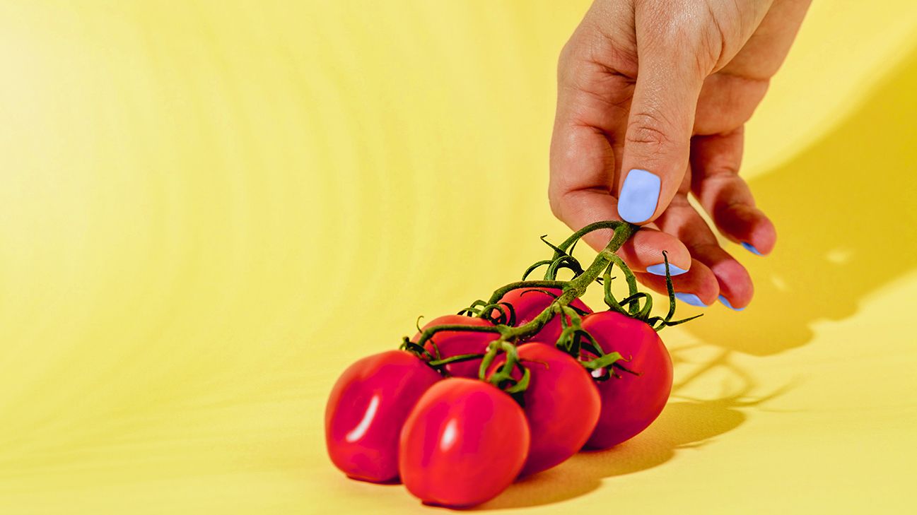 hand admiring low-carb tomatoes header