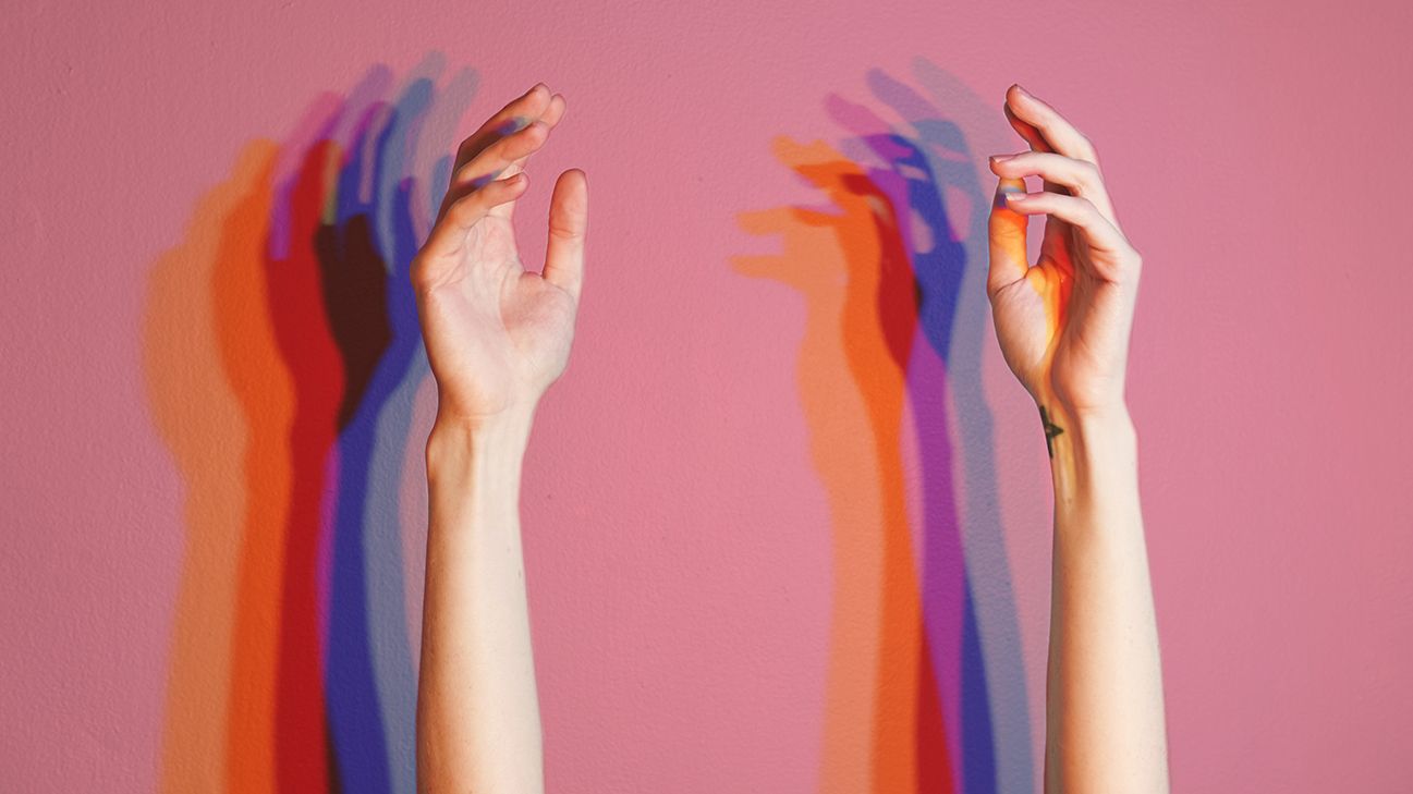 person with warm hands raising their arms against a wall