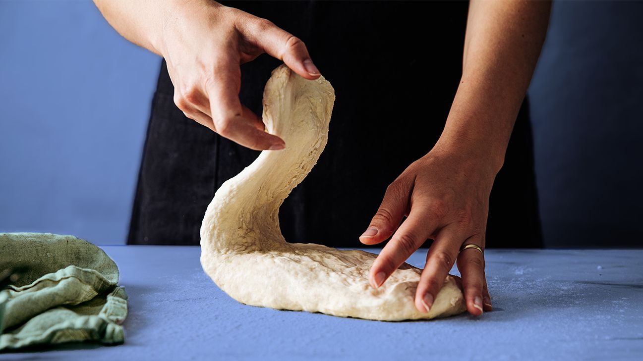 close up on hands kneading dough to simulate yeast 