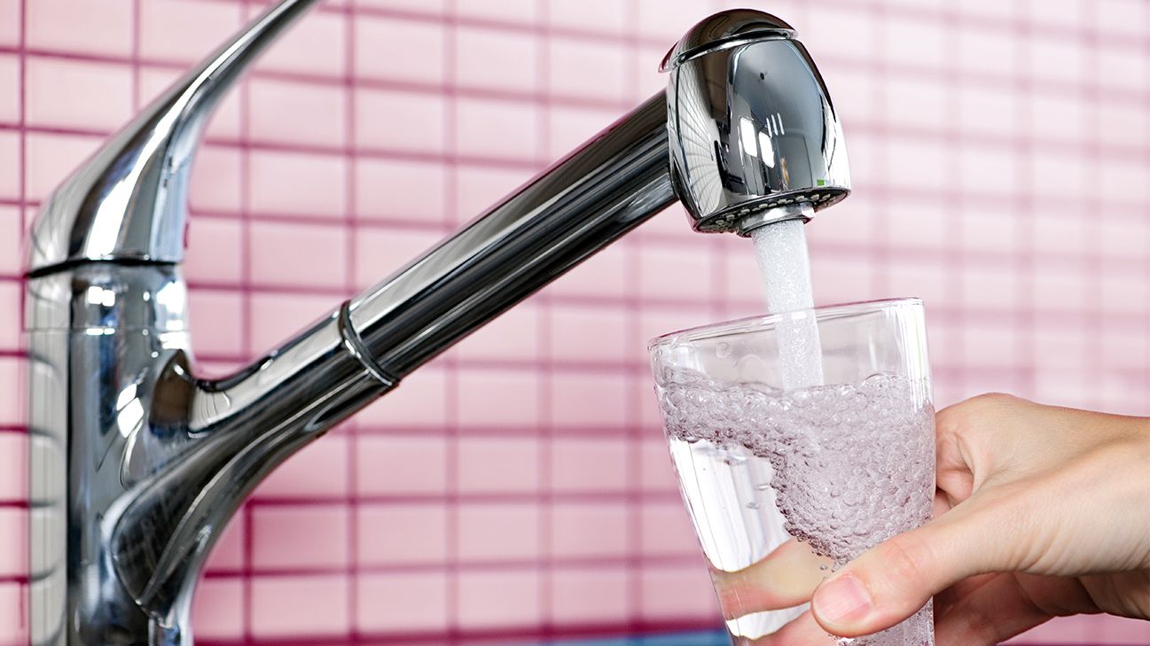 person pouring out purified water – but is it better than distilled? header