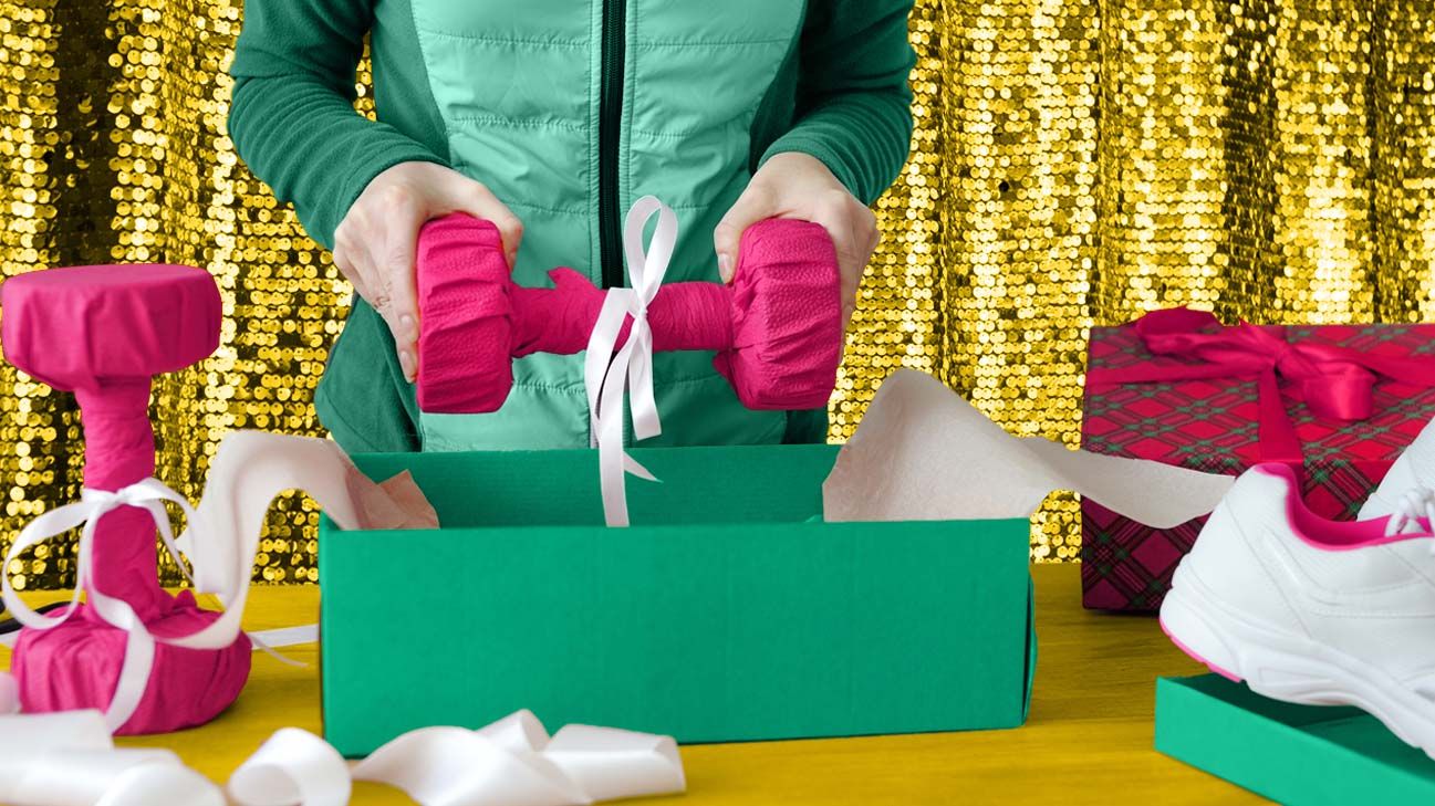 person in winter coat opening dumbbell-shaped present