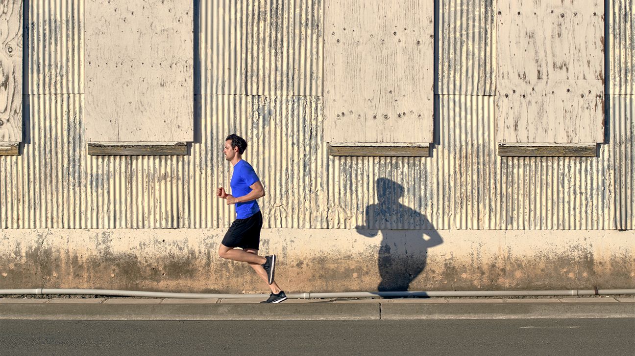man running down street followed by shadow header