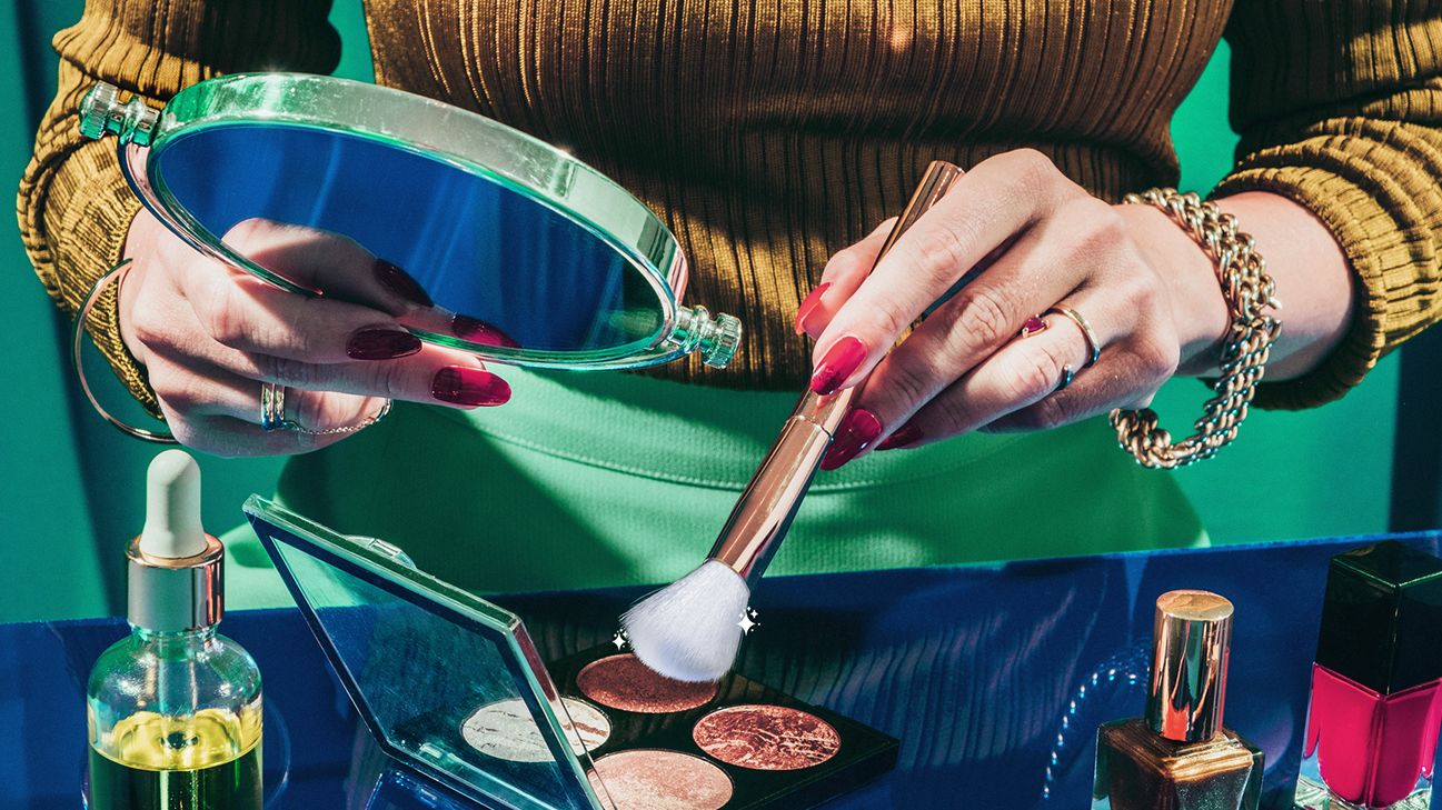 person dipping white bristle makeup brush into eyeshadow palette