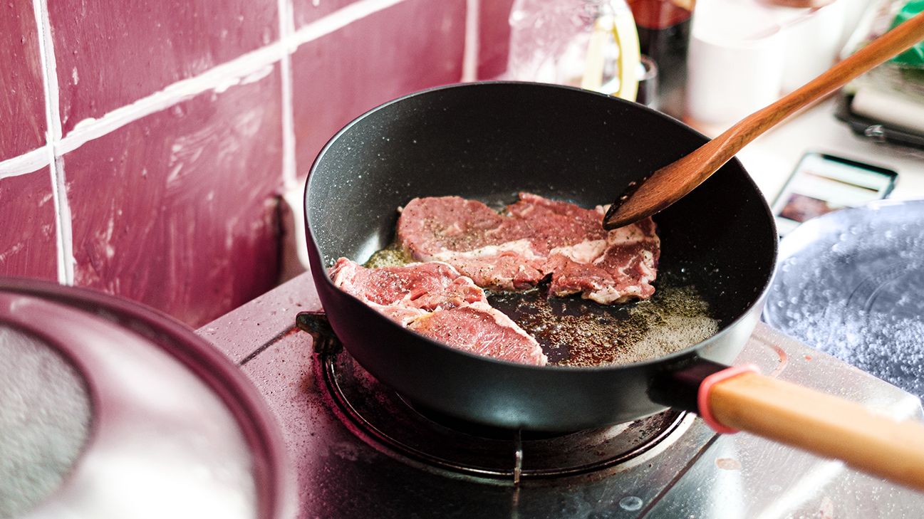 cooking beef in a pan on the stove