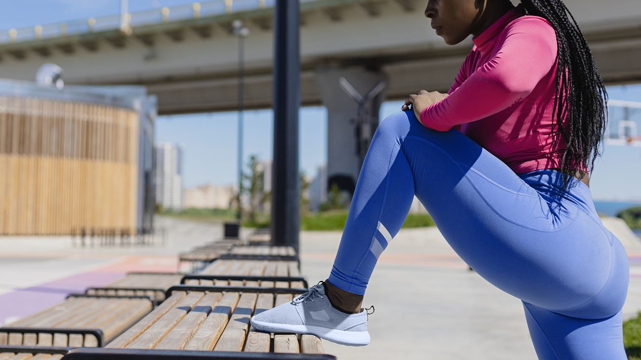 person stretching their glutes on bench