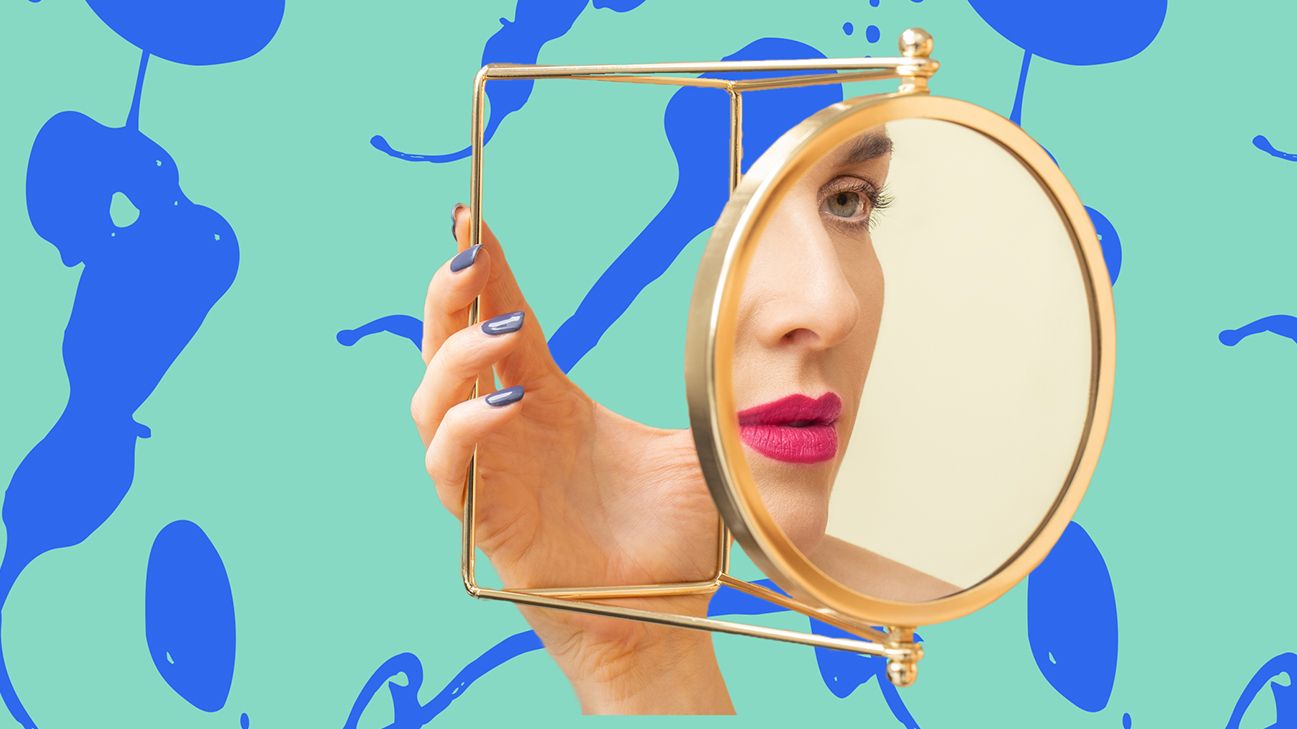 person wearing pink lipstick looking in oval gold mirror