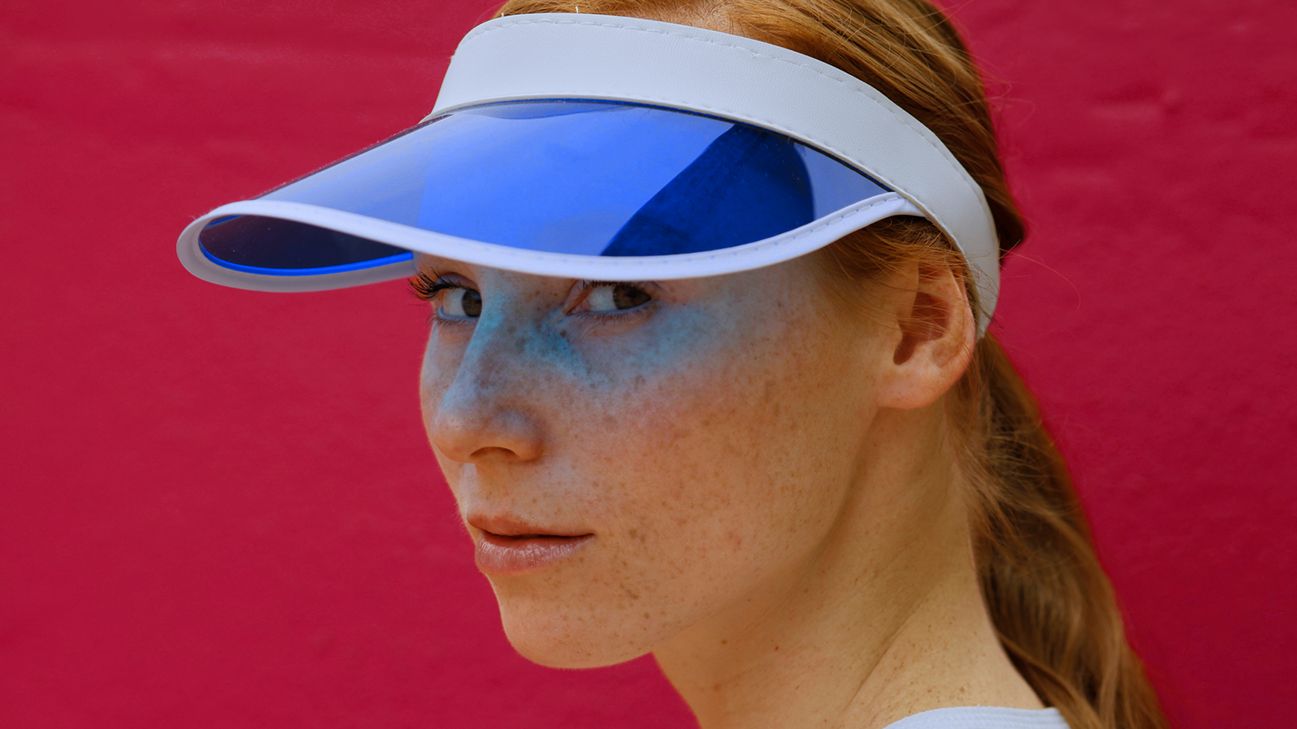 person wearing a blue sun visor to cover sunspots on face