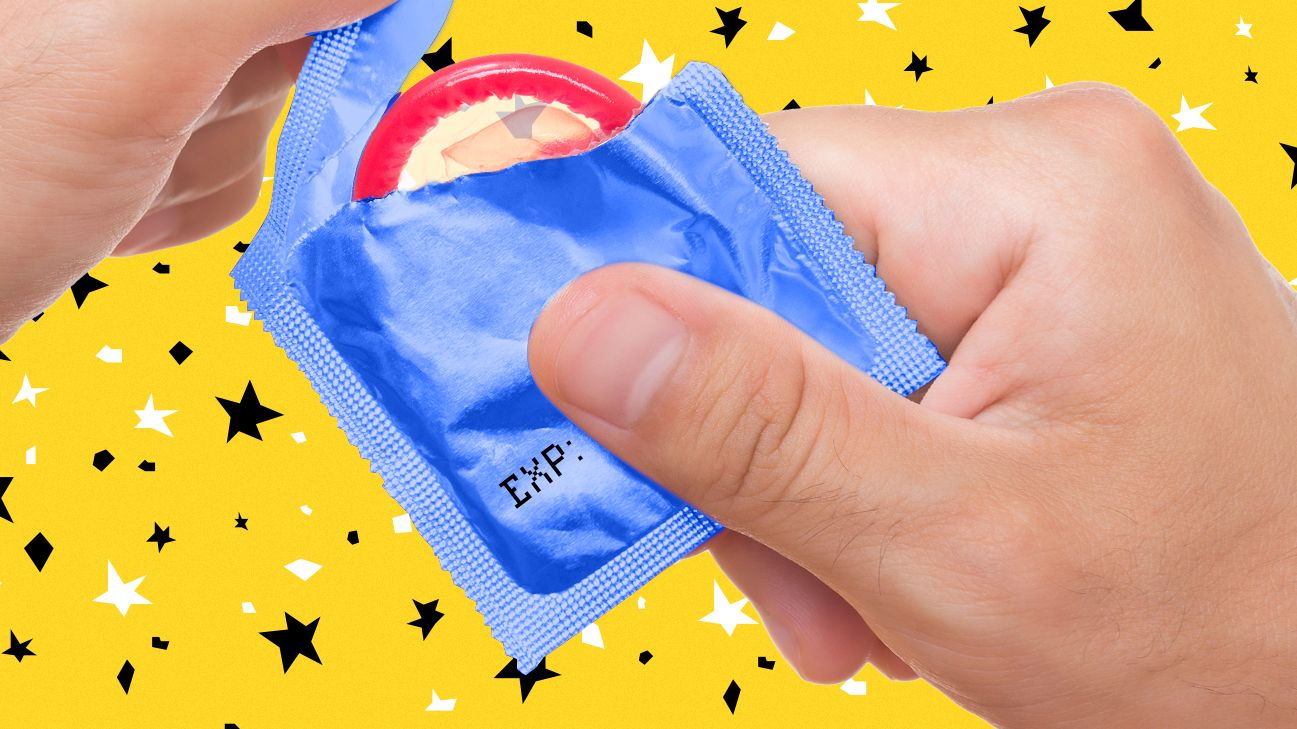 close-up of person opening condom wrapper