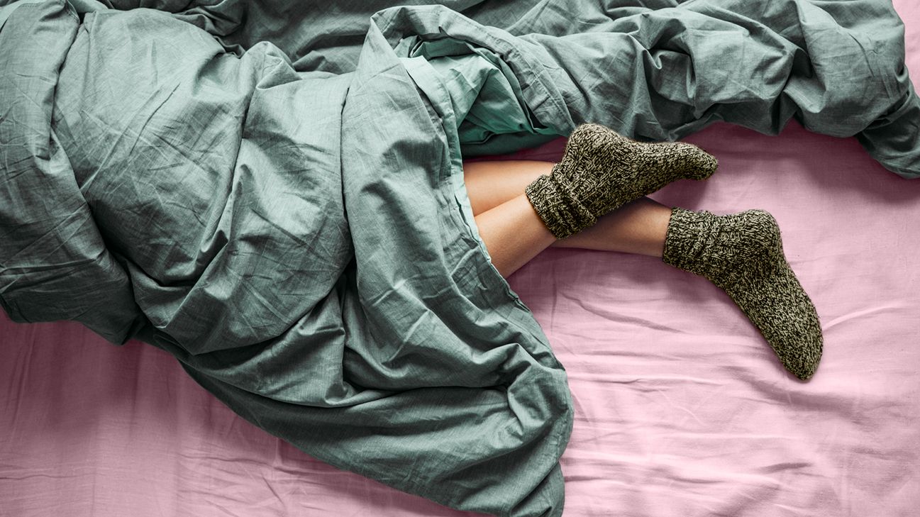person sleeping in bed with socks on
