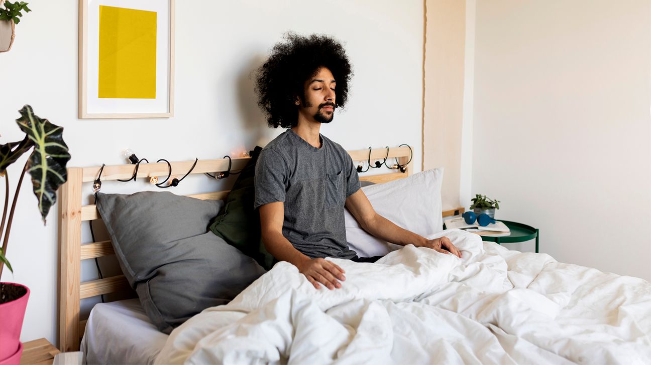 person meditating in bed