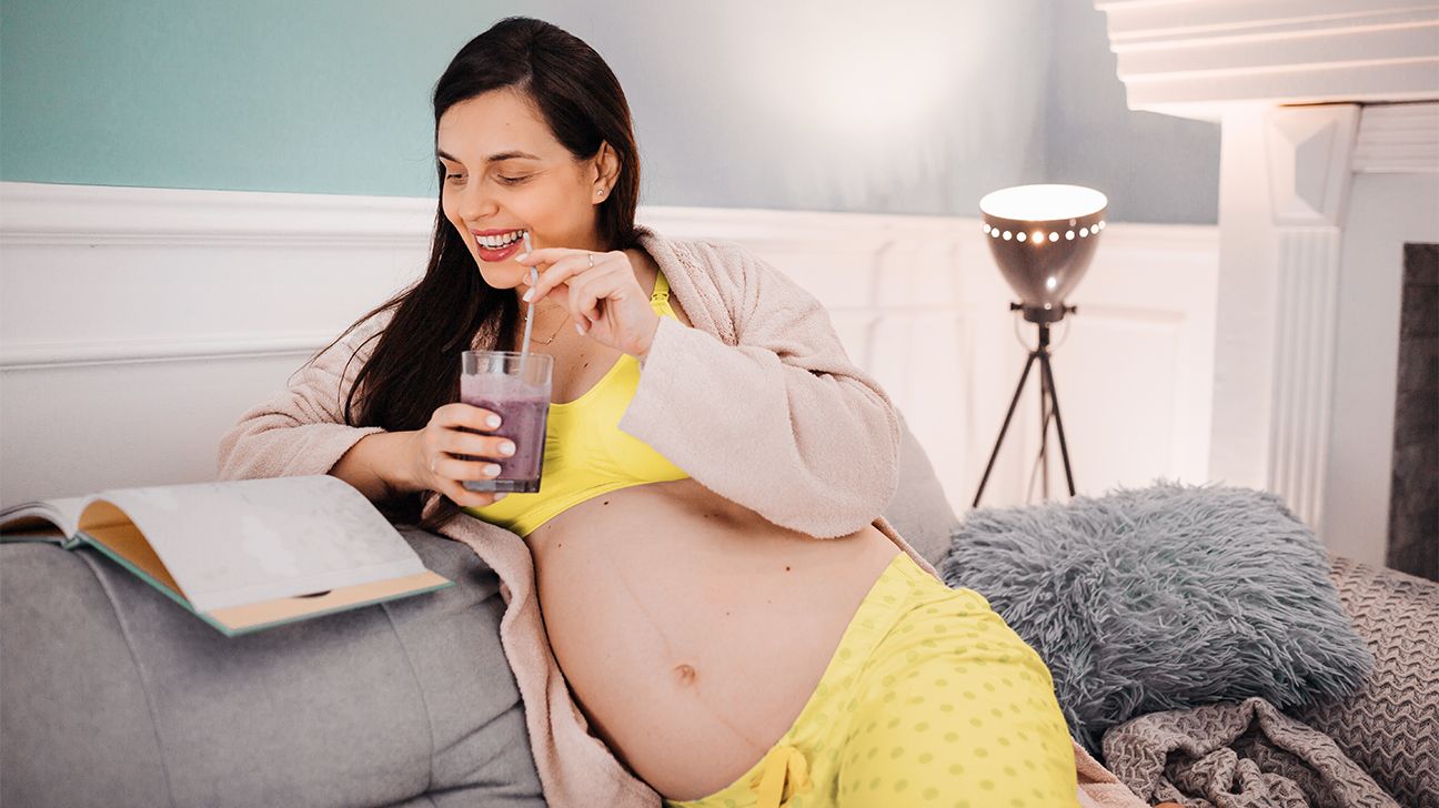 pregnant person drinking a smoothie