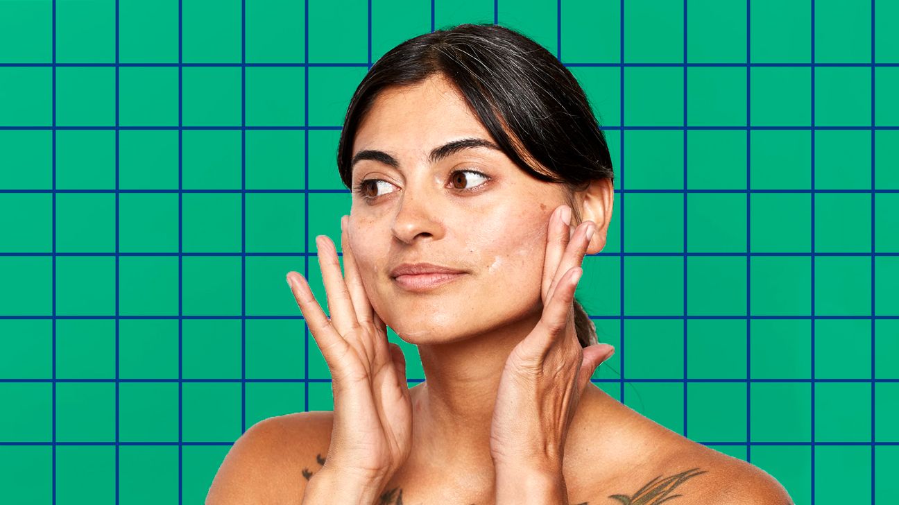 person applying face cream in front of green background