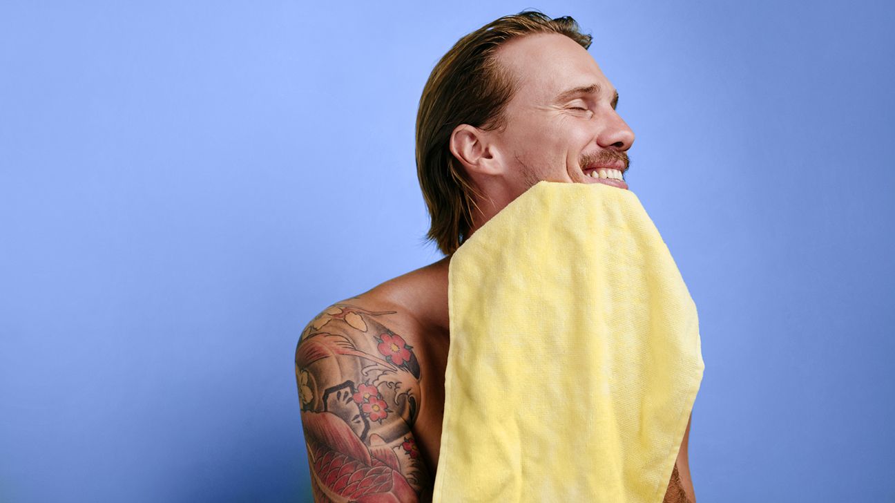 male smiling with towel while practising skin care header