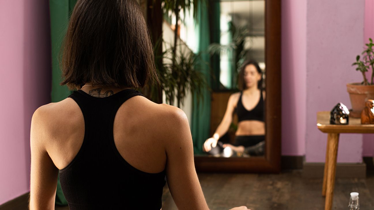 person sitting in front of the mirror meditating