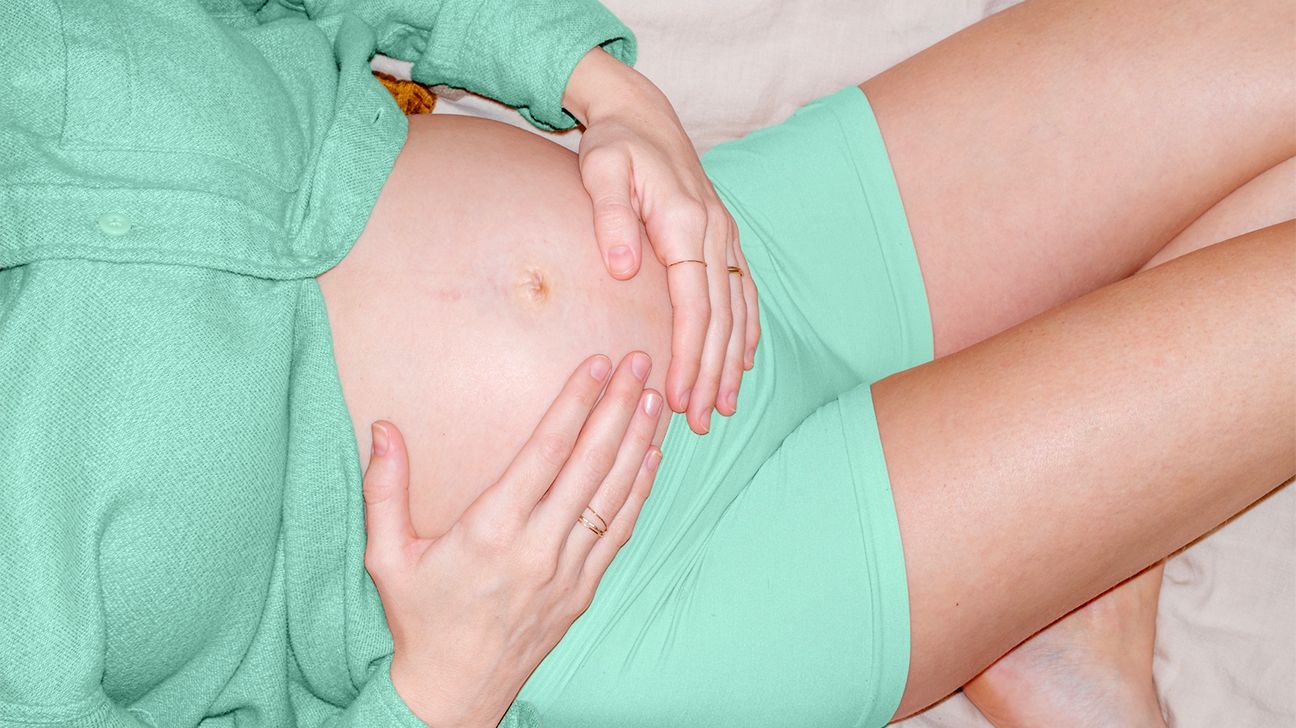 pregnant person holding stomach
