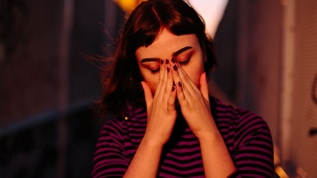 stressed out female covering face with hands