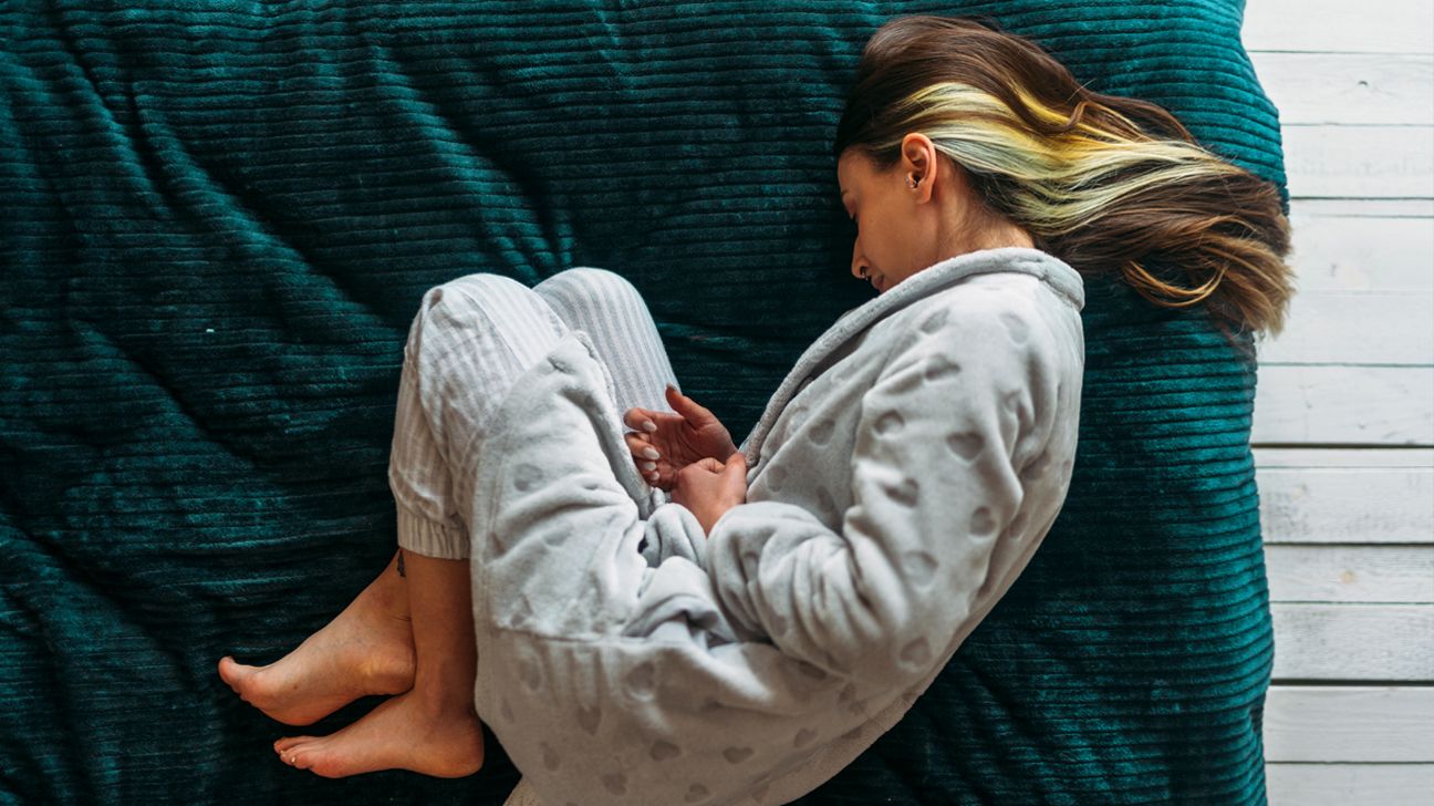 woman crouched in pain