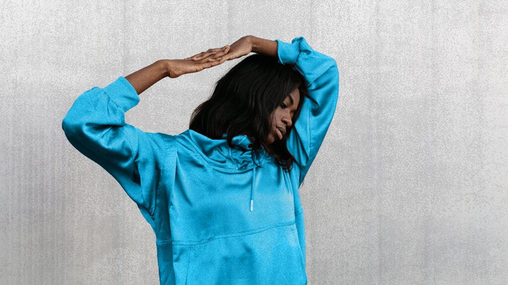 A person is a blue hoodie, stretching