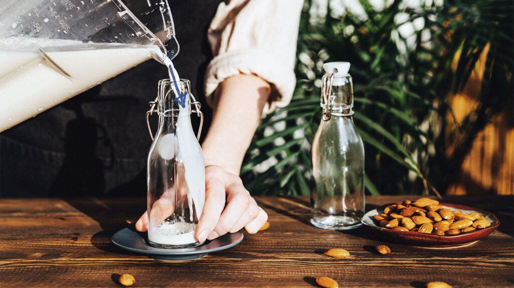 Woman making home made almond milk