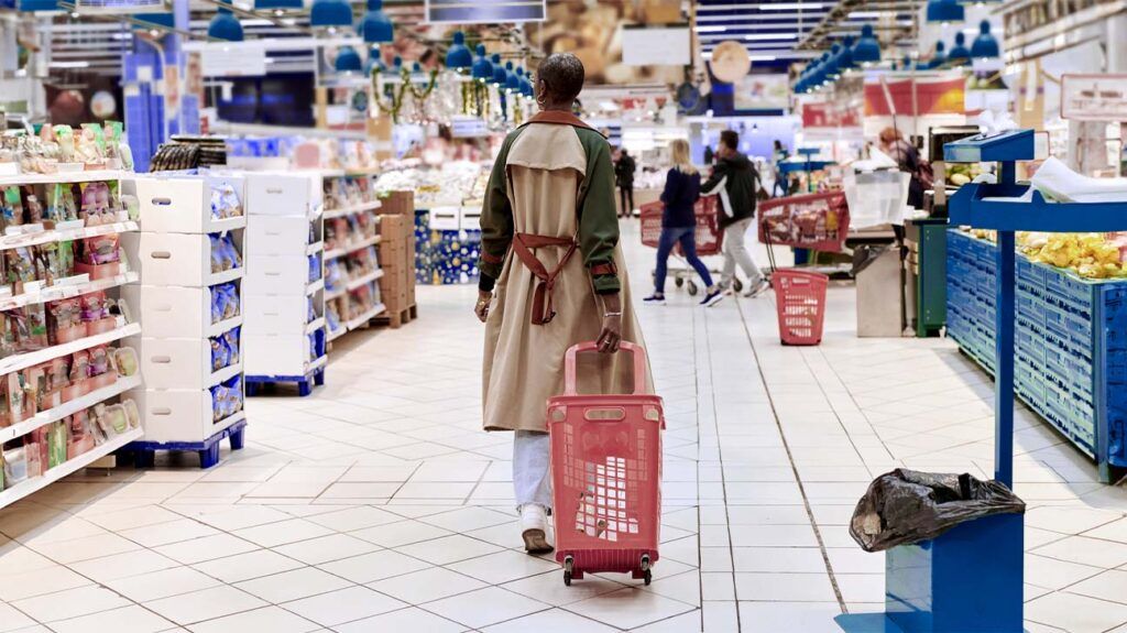 a woman pulling a trolly around a supermarket