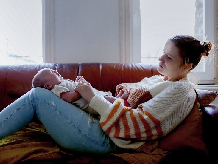https://media.post.rvohealth.io/wp-content/uploads/sites/3/2023/08/Tired-mother-consoles-hugs-her-baby-on-large-sofa-in-living-room-thumbnail-732x549.jpg