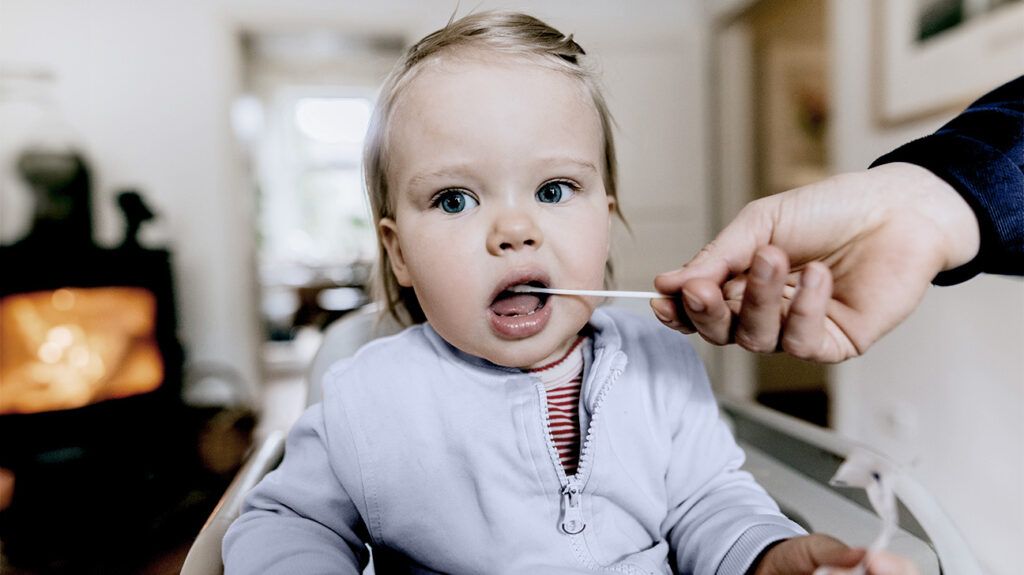 A baby having their mouth swabbed to test for cystic fibrosis -1.