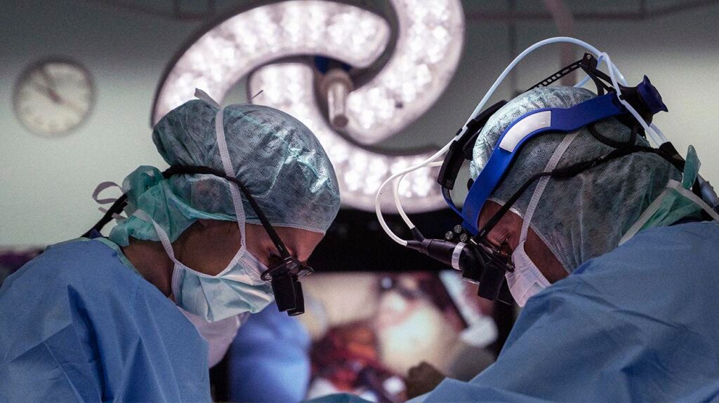 Two cardiac surgeons operating on a patient-1
