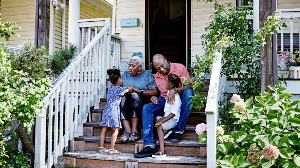 A Black family sitting on porch steps.-2