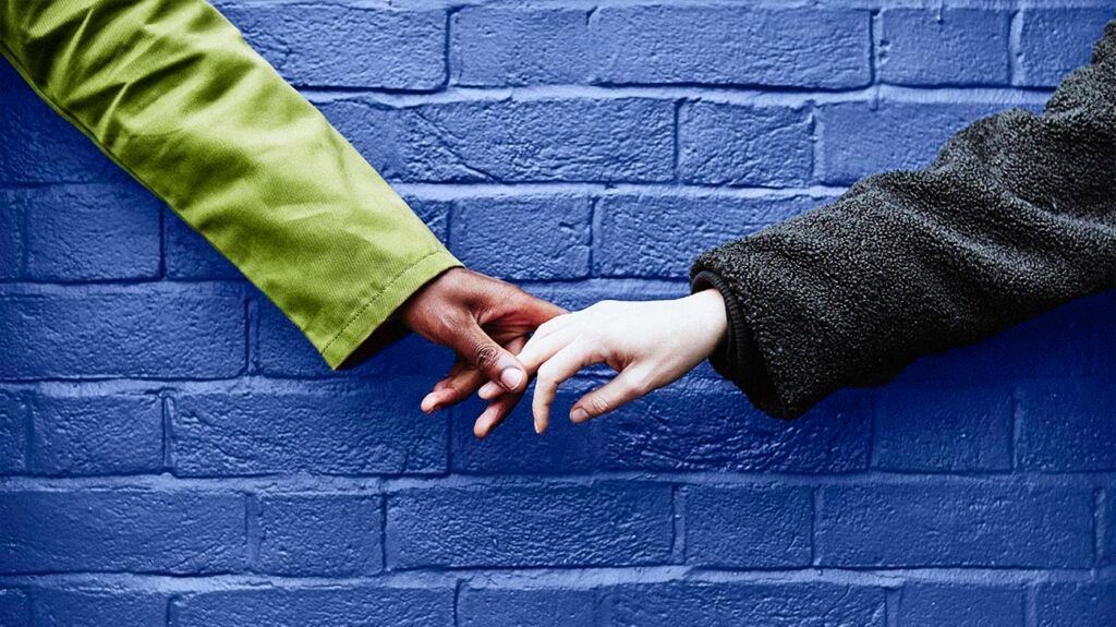 People holding hands against a blue wall -2.