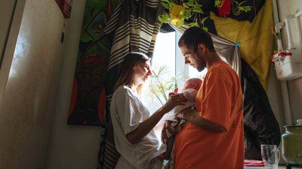 Parents are holding a baby.