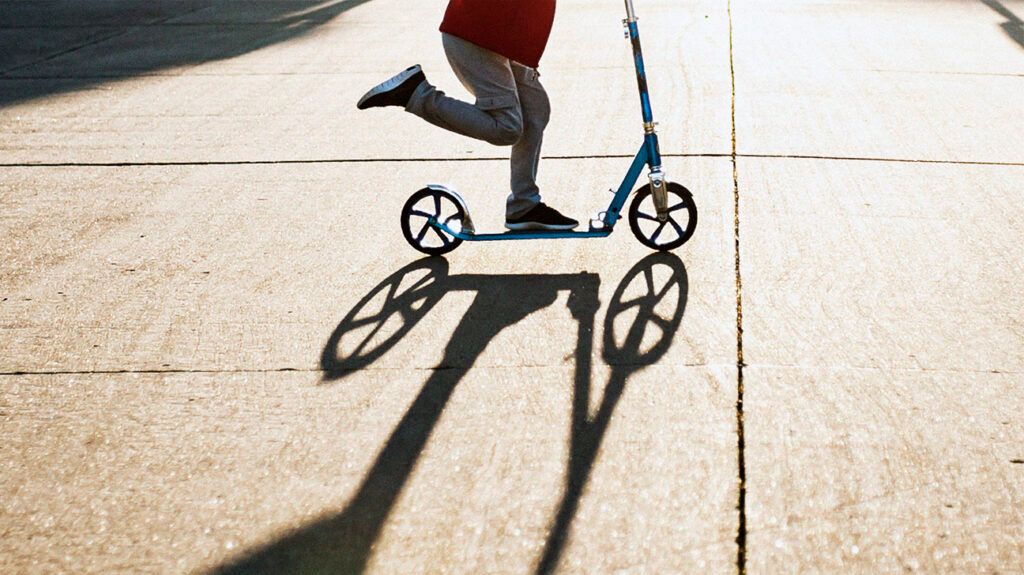 Lower half of a child playing on a scooter -2.