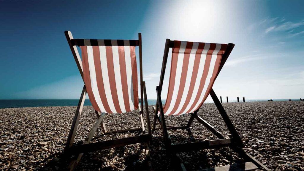 Deckchairs on a beach in the summer, when people may experience worsening hives.-1