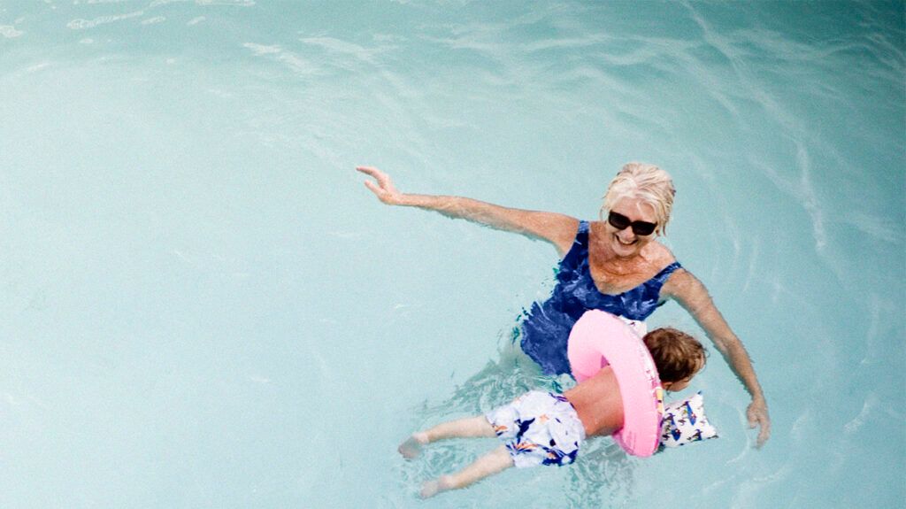 An older adult with a grandchild in a pool-2.
