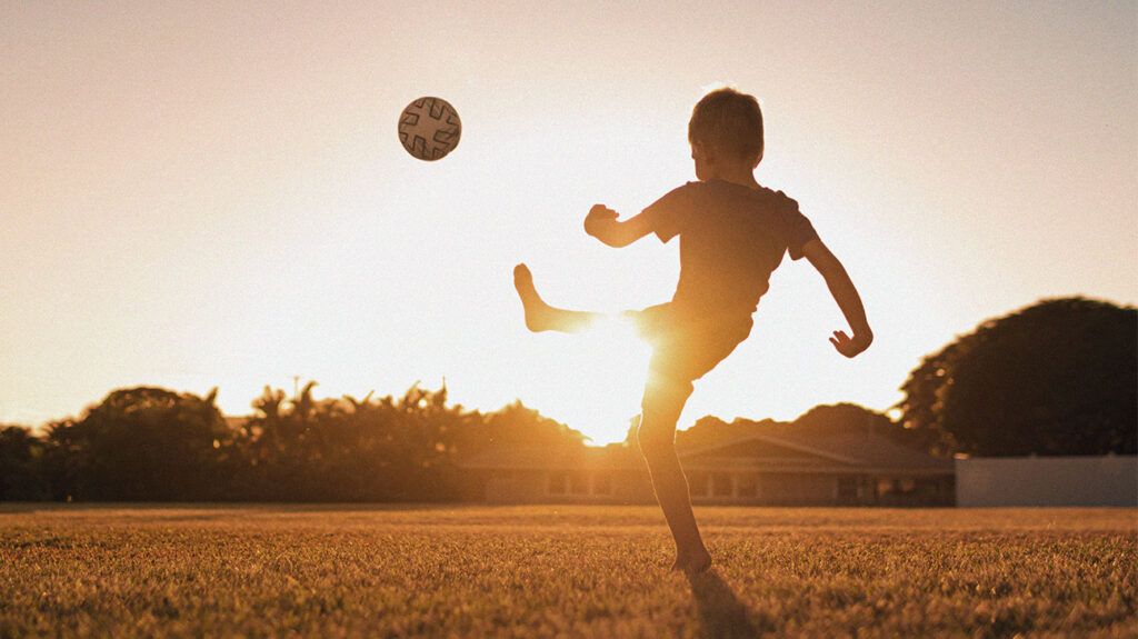 A child is kicking a ball.