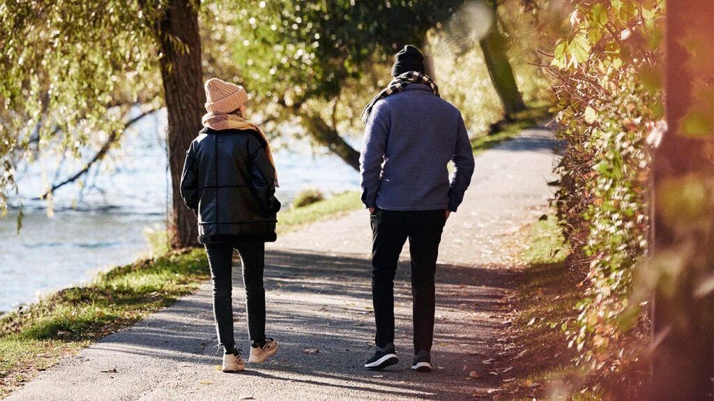 Man and woman walking in autumn park