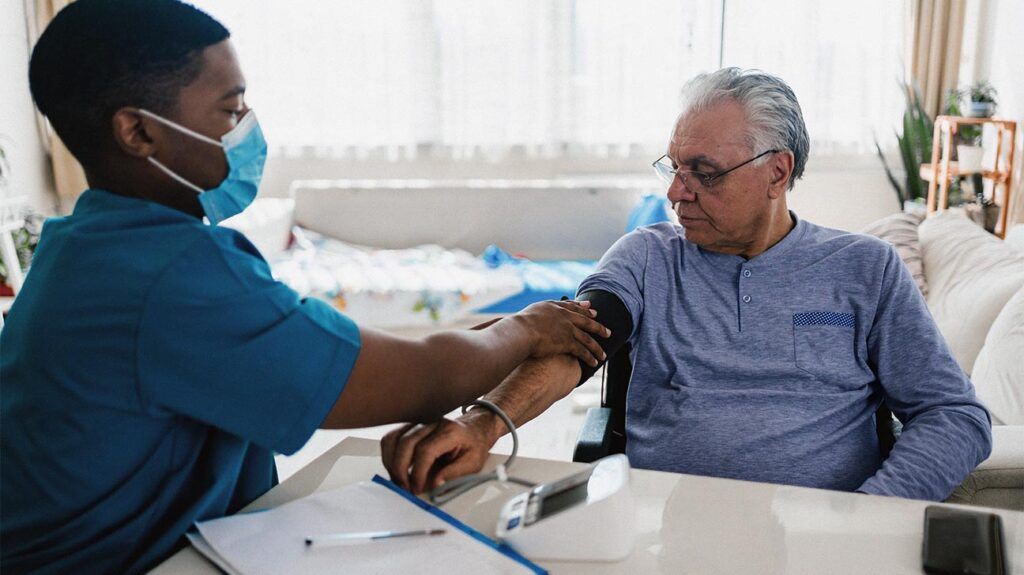 A healthcare professional measuring a man's blood pressure.