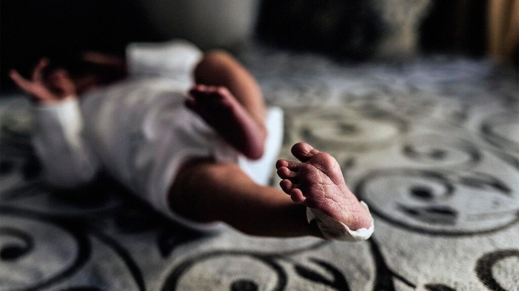 A newborn baby lying on a bed 1