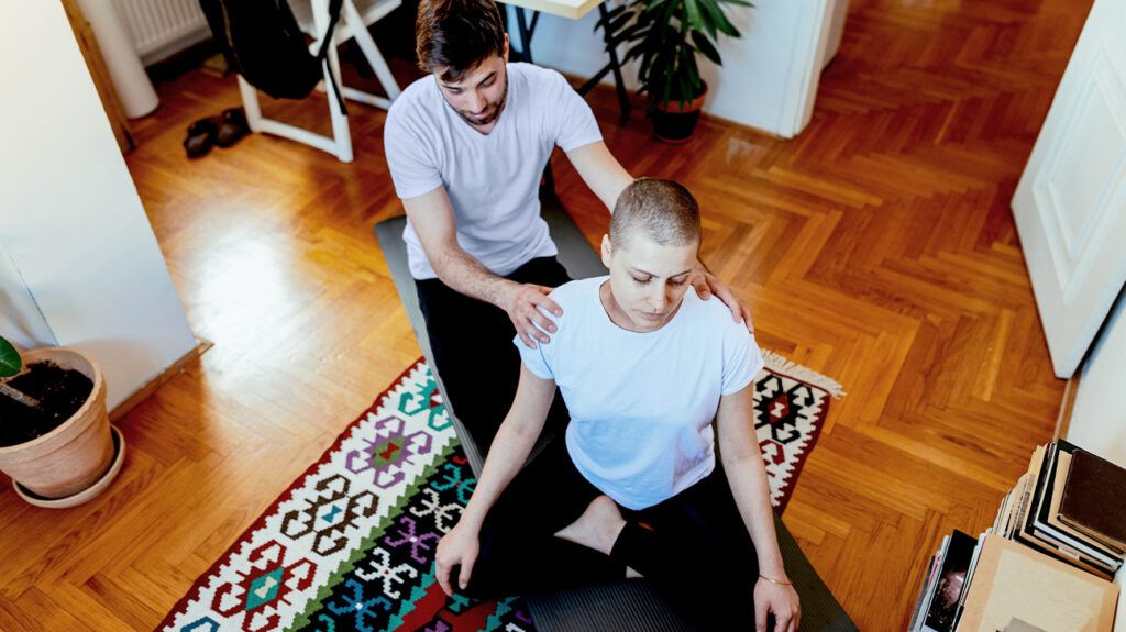 A couple doing yoga to help alleviate pain due to bone cancer -2.