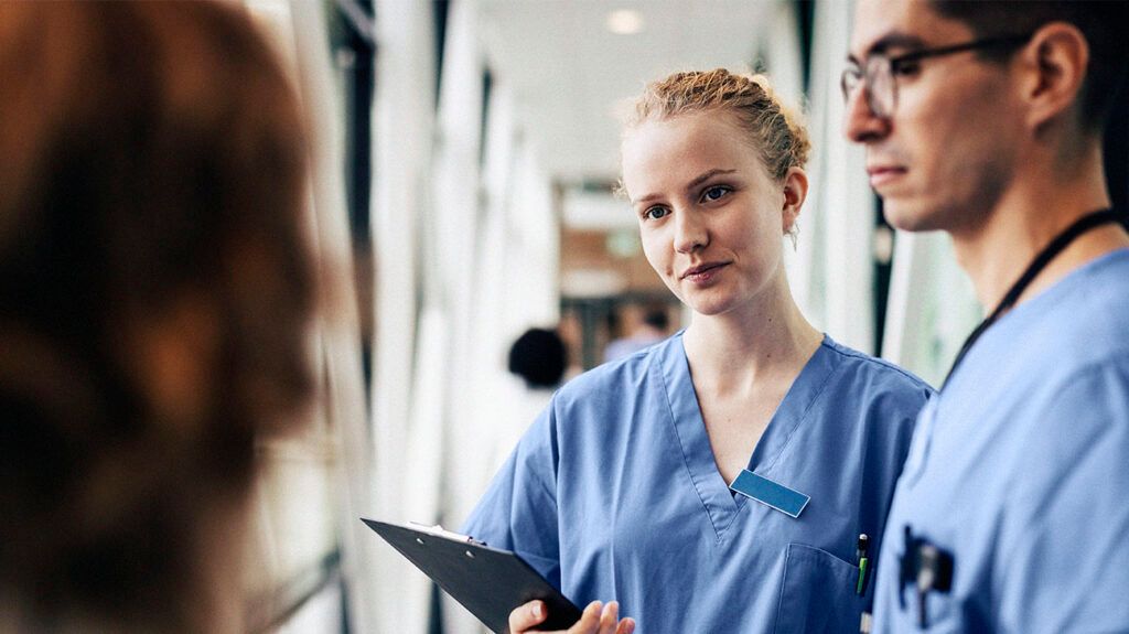 A healthcare professional holding a clipboard 1